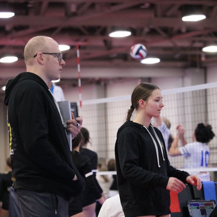Coach Adam Bromberg stands with Vegas Volley athlete, Mikaela, at a club volleyball tournament in Las Vegas, Nevada